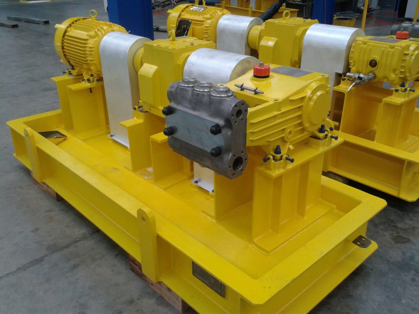 Packaged triplex plunger pump units on fabricated skids in a workshop